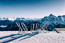 Three Empty Beach Chairs In Front Of Alpine Winter Panorama