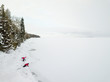 © blurMEDIA/Stocksy - Boy and girl have fun playing in snow on winter vacation between frozen lake ice and forest