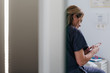 © MyMicrostock/Stocksy - Doctor woman having a break and checking her mobile phone