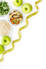 Wall Mural - Weight loss concept with green organic food on white background top view space for text