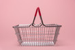 Shopping basket on pink background