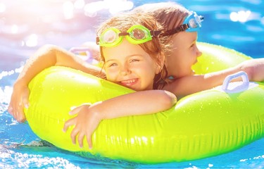 Children playing in pool. Two little girls having fun in the pool. Summer holidays and vacation concept