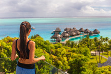 Luxury Bora Bora Hotel Resort Woman Tourist Overlooking View Of Overwater Bungalows Villas On Tahiti Ocean, French Polynesia.