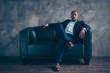 © deagreez - Portrait of his he nice classy chic attractive guy professional top manager ceo boss chief company director masculine sitting on couch at workplace station gray concrete wall