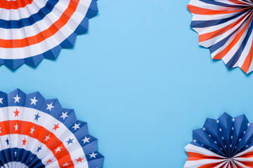 US flag colored paper star fans on blue background.