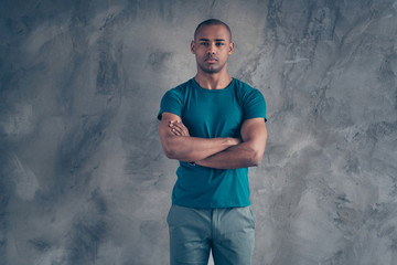 Wall Mural - Portrait of his he nice attractive sportive powerful good-looking guy wearing trendy blue t-shirt modern look isolated over gray industrial concrete wall
