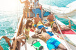 Happy friends having fun in summer boat party with dj mixing music - Young trendy people enjoying holiday on sail ship tour - Travel and friendship concept - Focus on bottom guys
