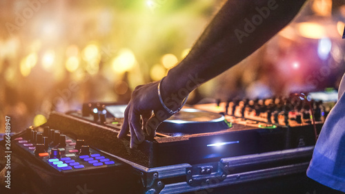 Fotografia  Dj mixing outdoor at beach party festival with crowd of people in background - S