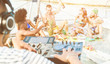 Happy friends drinking champagne in summer boat party - Young people having fun together with dj mixing music - Youth, holiday lifestyle and vacation concept - Focus on center man face