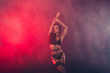 © deagreez - Nice attractive fascinating charming sportive perfect figure wavy-haired lady wearing swordbelt teasing posing closed eyes enjoying lifestyle night club clubber isolated on red light black background