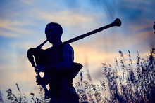 A Young Modern Man Plays Musical Bagpipes Outside. Siluet