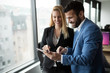 © NDABCREATIVITY - Businesspeople discussing while using digital tablet in office