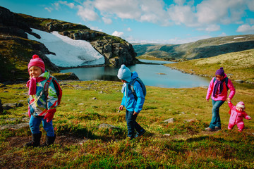 mother with kids travel hiking in mountains of Norway