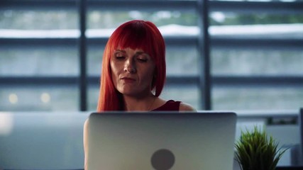 Wall Mural - A portrait of mature businesswoman in office, using laptop. Slow motion.