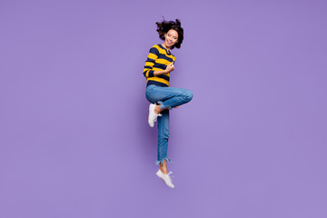 Wall Mural - Full length body size side profile photo beautiful she her lady hands arms fists air yell scream shout jump high flight playful mood wear blue yellow striped pullover isolated violet purple background