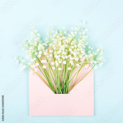 Bouquet of lily of valley in pink envelope.