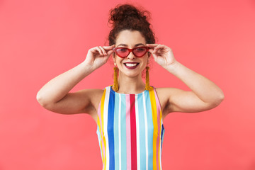 Canvas Print - Pleased pretty redhead woman in dress holding sunglasses