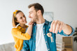 © LIGHTFIELD STUDIOS - Selective focus of happy couple with keys at home
