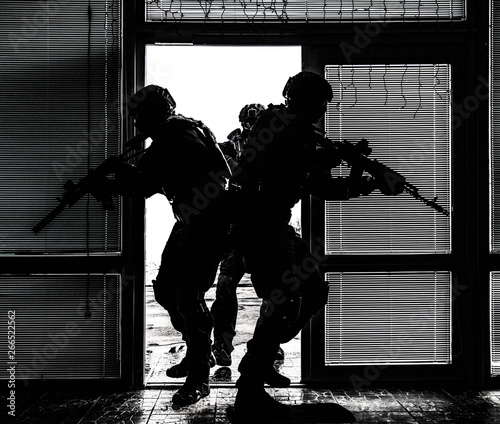 Fotografía SWAT team breaching door and storming apartments
