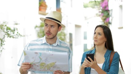 Wall Mural - Lost confused tourists searching direction checking phone and map on vacation