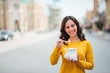 © bnenin - Positive young positive woman eating fast food in the city.