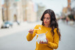 © bnenin - Young woman dissatisfied about takeout food in urban background.