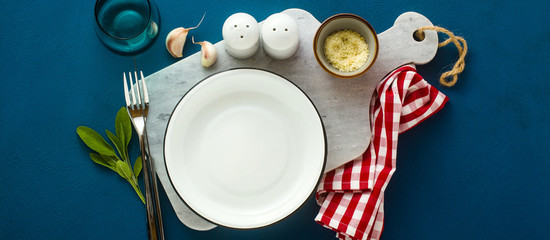 banner of empty served plate on marble serving board and blue spice background