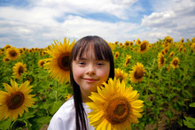Portrait Of Smiling Girl On Sunflower Field
