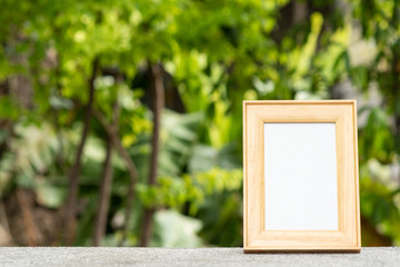 Photo frame on table with nature background.