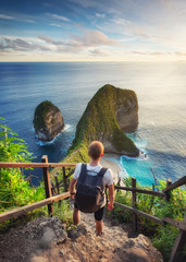 Wall Mural - traveler look at the ocean and rocks. travel and active life concept. adventure and travel on bali, 
