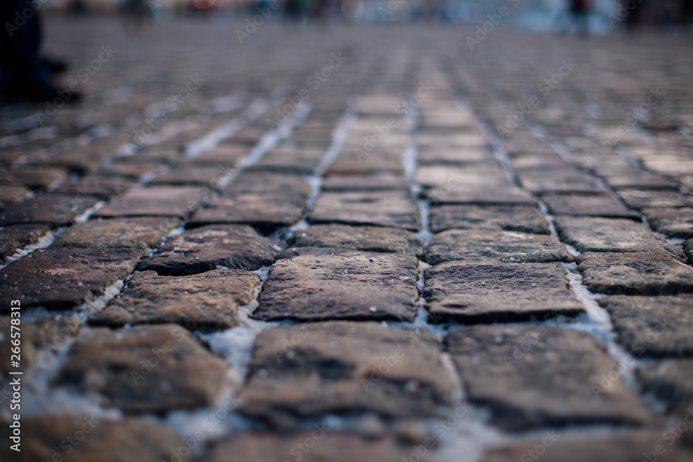 Stone pavement in perspective. Old street paved with stone blocks. Shallow depth of field. Vintage grunge texture. - obrazy, fototapety, plakaty 