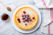Thin crepes with raspberry in white plate. Marble background. Top view.