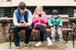 © Мар'ян Філь - Three children sit on a bench and look at the phones, instead of walking, resting the children playing games on the phone