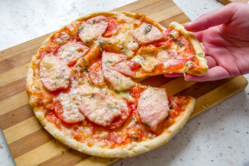 Man takes a slice of pizza close up