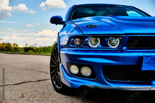 Fotomural Aggressive sport car in blue against the background of nature
