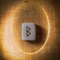 Wall Mural - Berkano. Handmade scandinavian wooden runes on a wooden vintage background in a circle of light. Concept of fortune telling and prediction of the future.