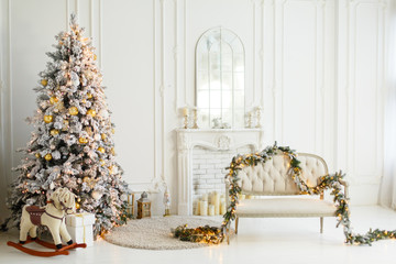 Wall Mural - Stylish Christmas light interior with a soft armchair or sofa decorated with garland. Comfort home. Christmas tree with presents underneath in living room