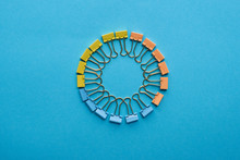 Top View Of Paper Clips Arranged In Round Shape Isolated On Blue