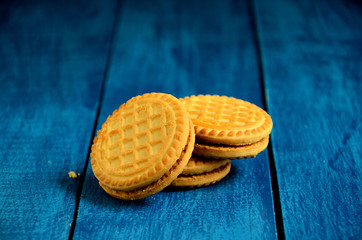 Round biscuits on a blue wooden table background.