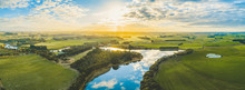 Sun Setting Over Scenic Australian Countryside Grasslands And Pastures With River Passing Through - Aerial Panorama