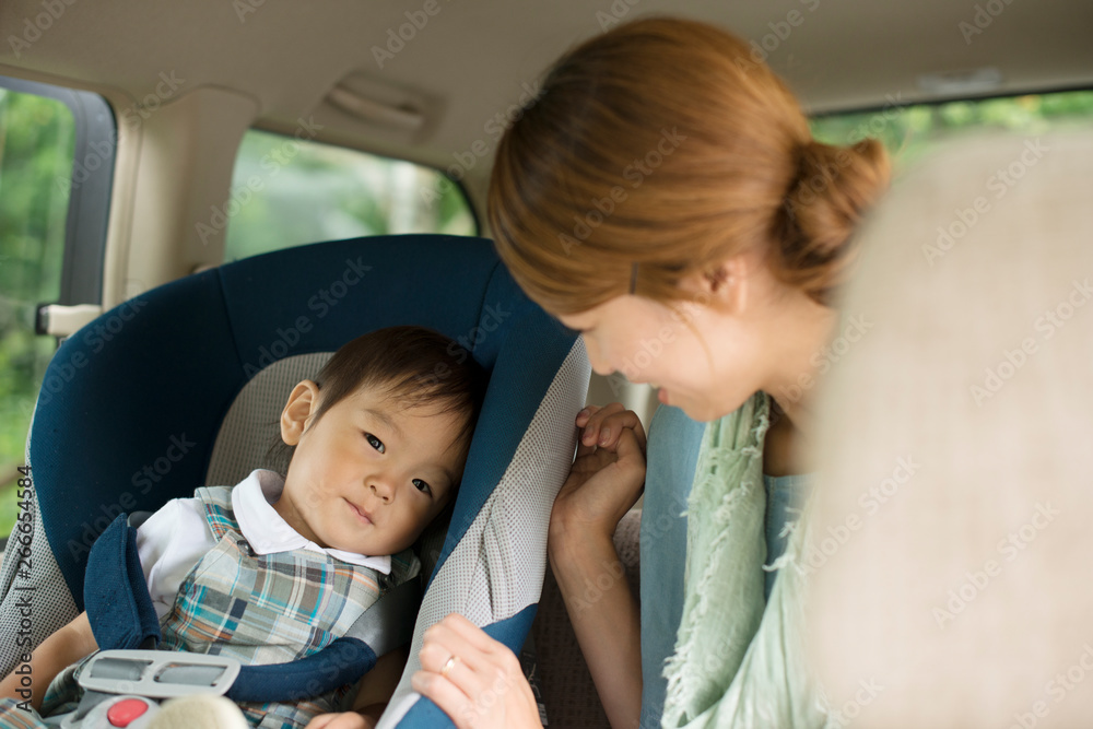 チャイルドシートに乗る子供と会話をする母親 Stock Photo | Adobe Stock