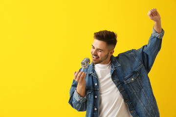 Wall Mural - Handsome male singer with microphone on color background