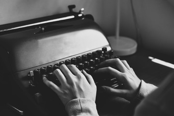 Hand typing typewriter on wooden table