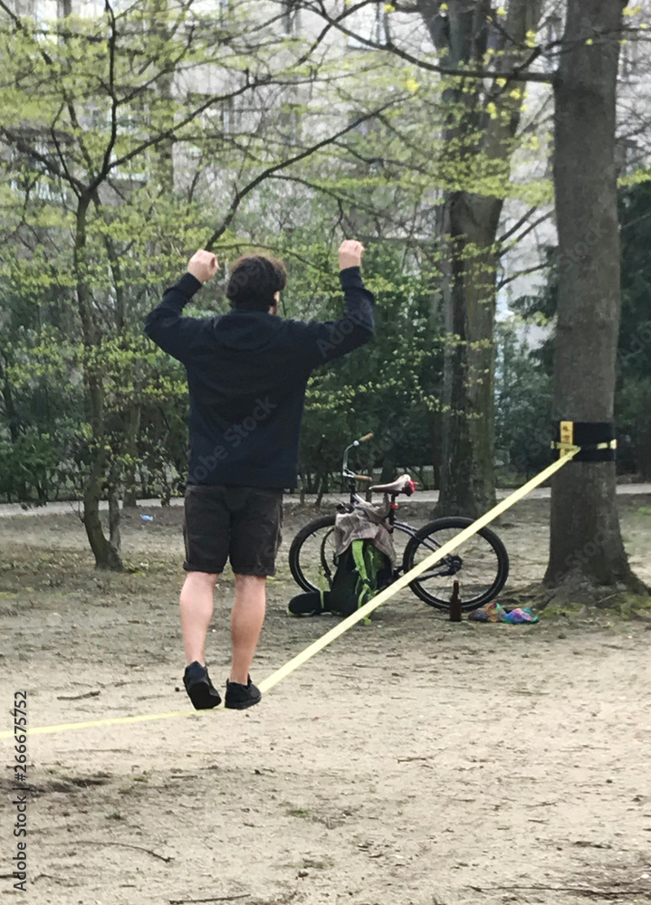 a young man balances on a rope stretched between two trees Stock Photo ...