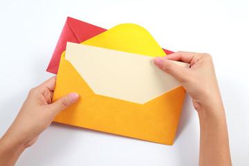 Wall Mural - Top view female hands holding a blank card with colorful envelopes on the table, isolated on white background