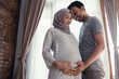 © Odua Images - asian muslim pregnant woman with her husband hold on tummy at home