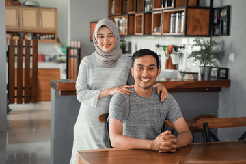 portrait of muslim couple sitting in dining room together