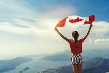 Child Girl Is Waving Canadian Flag On Top Of Mountain At Sky Background