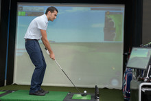 Golf Player Playing Video-game Golf Indoors