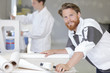© auremar - male worker smearing wallpaper with glue